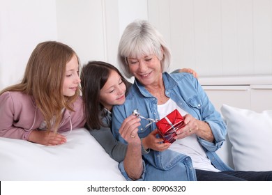 Girls offering present to grandmother - Powered by Shutterstock