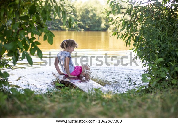 Girls On River Bank Kicks Feet Stock Photo Edit Now