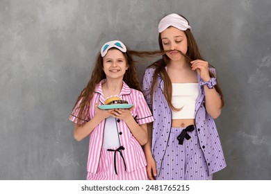 Girls at pajama party play with hair and eat desserts. Delightful moments shared during a family sleepover, highlighting the interactions, games, and familial bonds. Happy sisters - Powered by Shutterstock