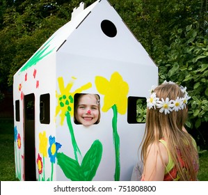 Girls Play With A Cardboard Wendy House