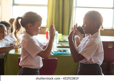 Girls Playing Clapping Game In School Canteen