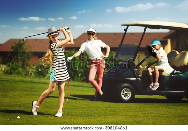 Girls playing\
golf at golf range at summer\
day