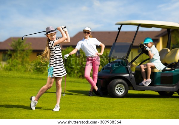 Girls playing\
golf at golf range at summer\
day