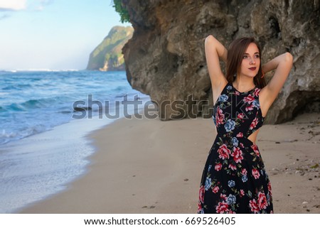 Girls posing on the beach in front of the rock. at dawn