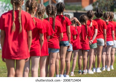 Girls in red T-shirts and shorts are lined up. - Powered by Shutterstock