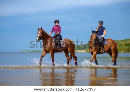 Girls riding a horse on coastline at the beach in early morning