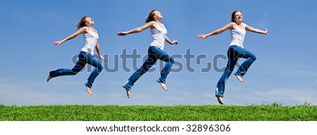Girls run on a green grass against the blue sky