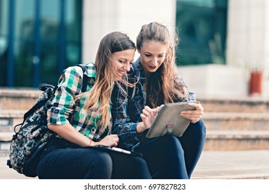 Girls seriously discussing about their studies on the first day of school. Standing outside school in trendy outfit. Happiness of seeing best friend is on their faces. Student girls back to school