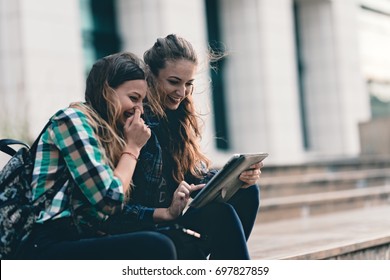 Girls Seriously Discussing About Their Studies On The First Day Of School. Standing Outside School In Trendy Outfit. Happiness Of Seeing Best Friend Is On Their Faces. Student Girls Back To School