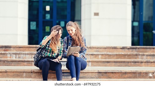 Girls Seriously Discussing About Their Studies On The First Day Of School. Standing Outside School In Trendy Outfit. Happiness Of Seeing Best Friend Is On Their Faces. Student Girls Back To School