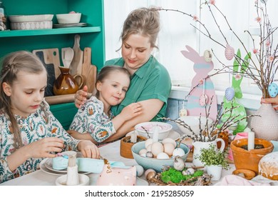 Girls, Sisters, Mother At Table With Easter Decoration. Celebration In Kitchen.Tablescape For Home Easter Holiday.Family Religious Traditional Festive Food, Meal. Colored Eggs,cake, Fun, Bunny Ears.