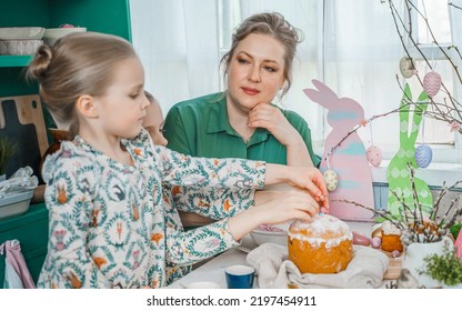 Girls, Sisters, Mother At Table With Easter Decoration. Celebration In Kitchen.Tablescape For Home Easter Holiday.Family Religious Traditional Festive Food, Meal. Colored Eggs,cake, Fun, Bunny Ears.