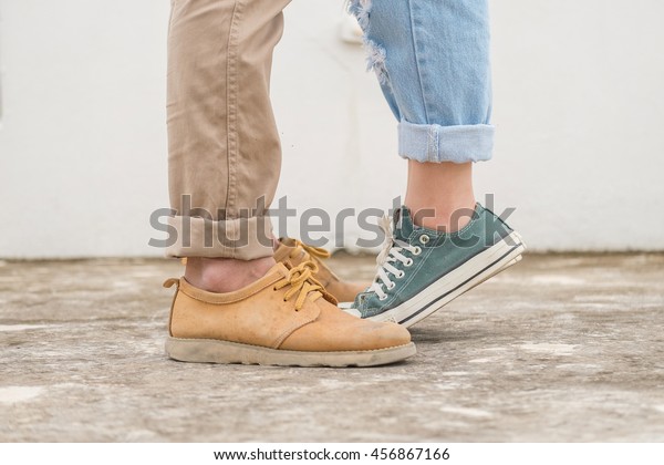 girls stands on tiptoe to kiss her man - Close up\
on shoes