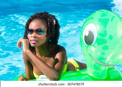 Girls in swimming pool water with inflatable anmimal