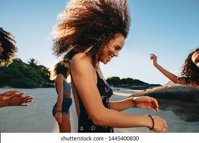 Girls in swimwear partying on the beach and dancing. Happy young female friends having fun at beach. - Powered by Shutterstock