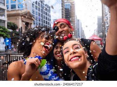 Girls taking selfie at street party parade, brazilian carnaval. Group of Brazilian friends in costume celebrating.