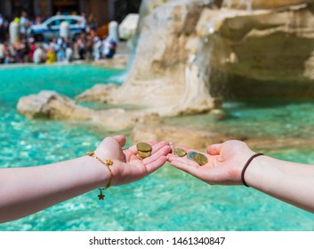 Girls Throwing Coin At Trevi Fountain For Good Luck. Hands Keeping Coin. Trevi Fountain, Rome, Italy. 
