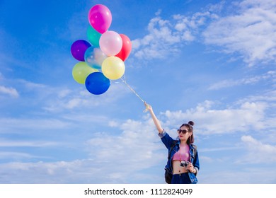 girl's travel and holds a ball of light color on a bright day sky background