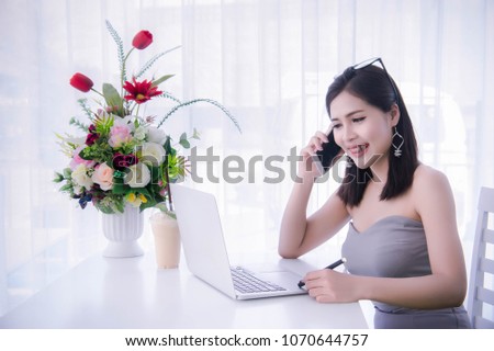 girl's using smart phone and working on laptop ,happy time on work, smile and laughing time work , workingwomen get think about work