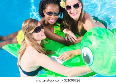 Girls in water of swimming pool with inflatable anmimal