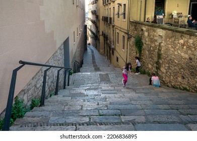 Girona, Catalonia, Spain Paril 15th 2022: Happy Children Running And Playing In A Narrow Streets With Stairs In Girona Spain.  Kids Having Fun Stepping Walking Up Stairs 