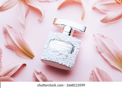 GIRONA, SPAIN - MARCH 9, 2020: Perfume Bella Blanca By Oscar De La Renta Surrounded With Flowers And Petals On Pink Background Close Up, Luxury Eau De Parfum