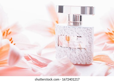 GIRONA, SPAIN - MARCH 9, 2020: Perfume Bella Blanca By Oscar De La Renta Surrounded With Flowers And Petals On Pink Background Close Up, Luxury Eau De Parfum