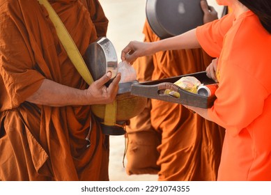 Give alms, Thai Buddhist to do good things make merit by offering food to the monk