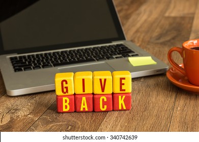 Give Back Written On A Wooden Cube In A Office Desk