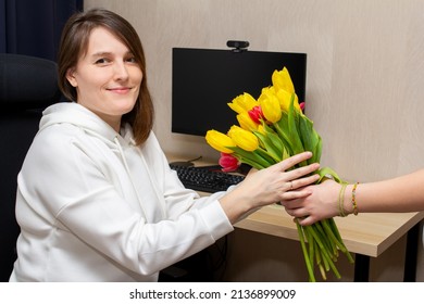 Give Flowers To A Girl Working At A Computer. Congratulations Woman At Work