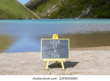 Give it a try symbol. Concept word Give it a try on beautiful black chalk blackboard. Beautiful mountain lake background. Business give it a try concept. Copy space. - Shutterstock ID 2395043083