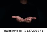 Give two hands with nothing on both on dark background with copy space. Close-up receiving gesture of outstretched cupped empty open hands. Concept of giving, donation, receiving, asking, and bribery.