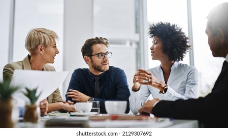 Give us difficult and well show you easy. Shot of a group of businesspeople sitting together in a meeting. - Shutterstock ID 2129307692