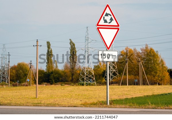 Give way sign at a roundabout. Circular motion.\
Traffic signs.