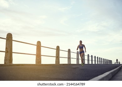 Give It Your All And You Can Have It All. Shot Of A Fit Young Woman Out For A Run On The Promenade.