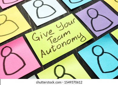 Give Your Team Autonomy sign and drawn smiles faces.