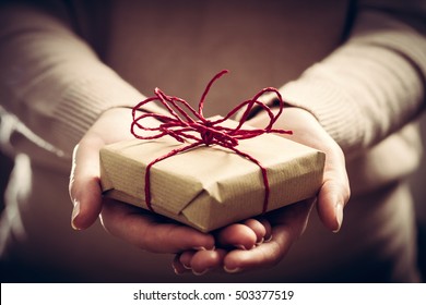 Giving a gift, handmade present wrapped in paper. Christmas time, vintage mood. - Shutterstock ID 503377519