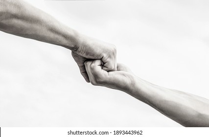 Giving a helping hand. Hands of man and woman on sky background. Lending a helping hand. Hands of man and woman reaching to each other, support. Black and white.