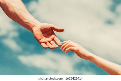 Giving a helping hand. Lending a helping hand. Hands of man and woman reaching to each other, support. Hands of man and woman on blue sky background.