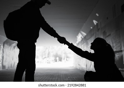 Giving A Helping Hand. Man Giving Woman Help Off The Street Showing Kindness And Compassion 