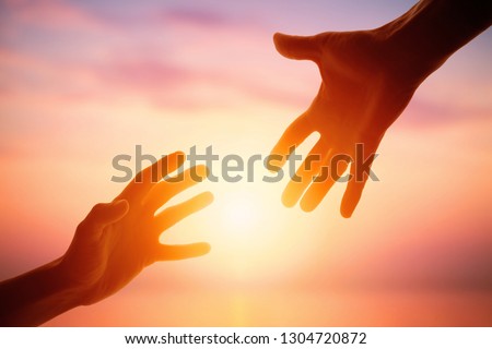 Giving a helping hand on the background of the dawn
