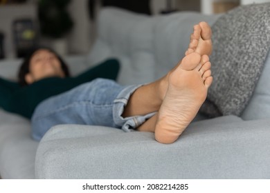 Giving Rest To Feet. Young Casual Lady Relax On Sofa Barefoot. Selective Focus On Well Groomed Female Feet With Soft Clean Smooth Beautiful Skin. Professional Salon Pedicure Foot Care Result. Close Up