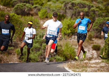 Giving it their all. a group of young men running a marathon.