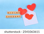 Giving Tuesday, international charity day background with red heart and text Giving Tuesday on blue background top view copy space. Global charitable giving day after Black Friday shopping day