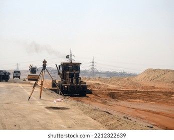 Giza, Egypt, July 25 2022: Ground Leveling With Grader Truck And Laser Leveler In The Process Of Paving A Road Before Making Asphalt Emulsion In Construction Of New Roads In Egypt Real Estate Projects