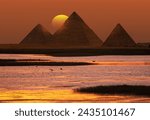 Giza pyramid Complex by the Nile at amazing sunset - Fishermen casting their fishing nets on a boat in Nile river at amazing sunset - Egypt