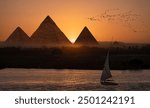 Giza pyramid Complex by the Nile at amazing sunset - Fishermen casting their fishing nets on a boat in Nile river at amazing sunset - Egypt