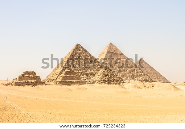Giza pyramids in Cairo, Egypt. General view of\
pyramids from the Giza Plateau Three pyramids known as Queens\'\
Pyramids on front side. Next in order from left, the Pyramid of\
Menkaure, Khafre and Chufu
