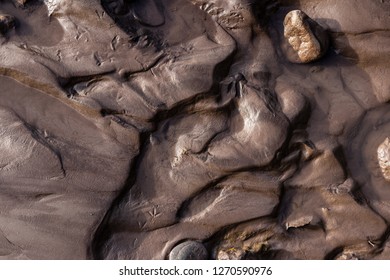 Glacial Riverbank Shore With Wet Black Silt Sand Mud Water Channels