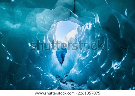 Glacier cave in Iceland with trapped ash inside the ice
